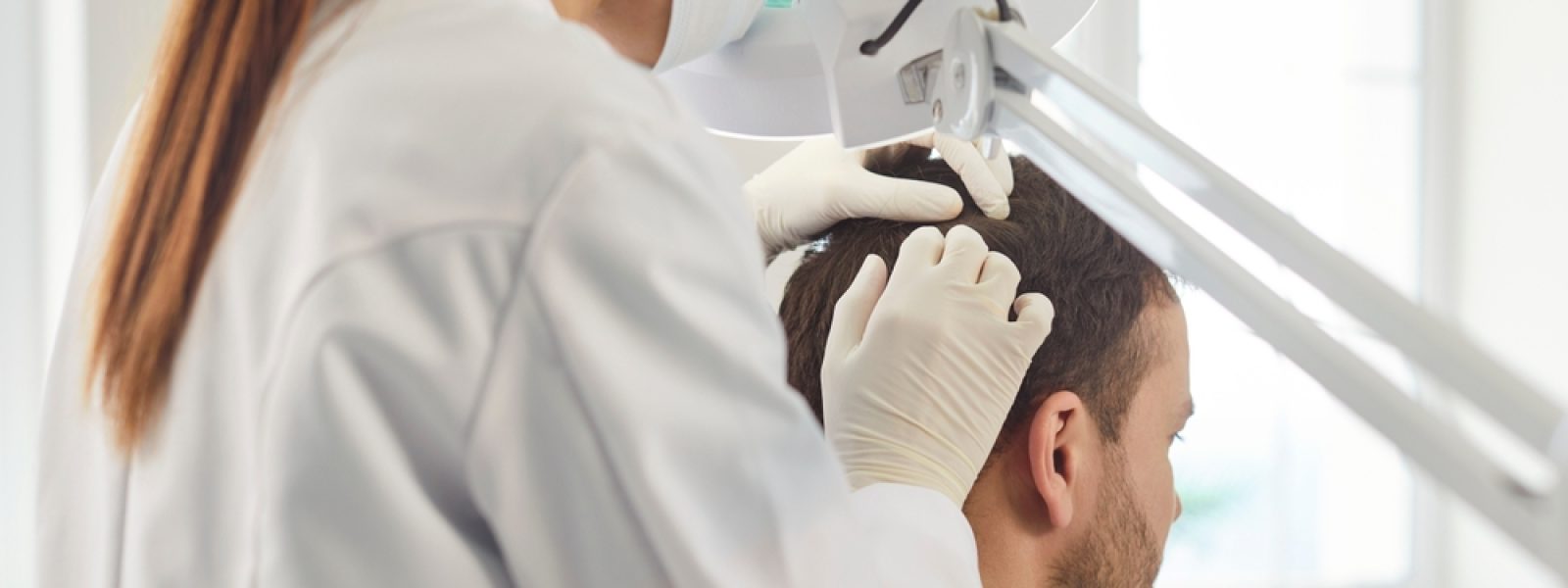 Female,Doctor,Dermatologist,Trichologist,With,Magnifying,Lamp,Examines,Man,With
